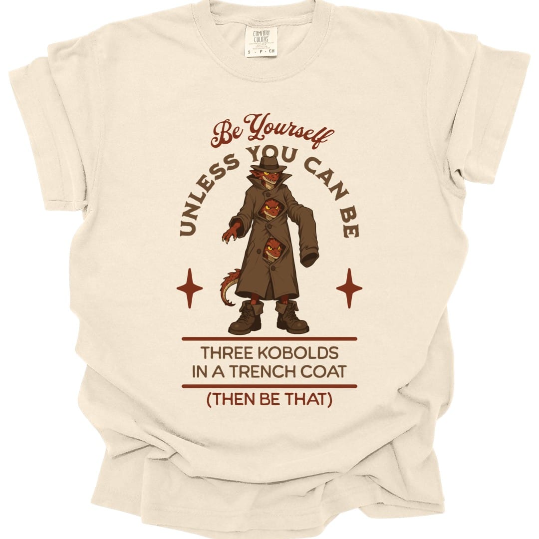 The same Three Kobolds in a Trench Coat design, on an ivory t-shirt.