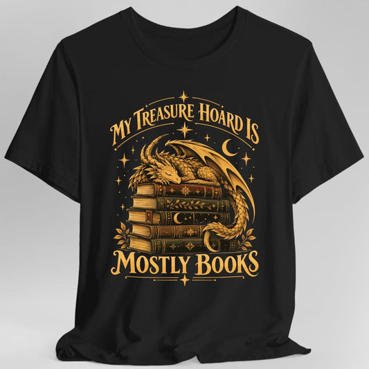 Black t-shirt. The design reads MY TREASURE HOARD IS in arched gold capitals across the top and MOSTLY BOOKS in large gold capitals at the bottom. Between them a scaled golden dragon sleeps curled on a stack of five old hardback books, its wing raised and its tail hooking around the spines. A crescent moon, scattered stars and small leaf sprigs fill the space around it.