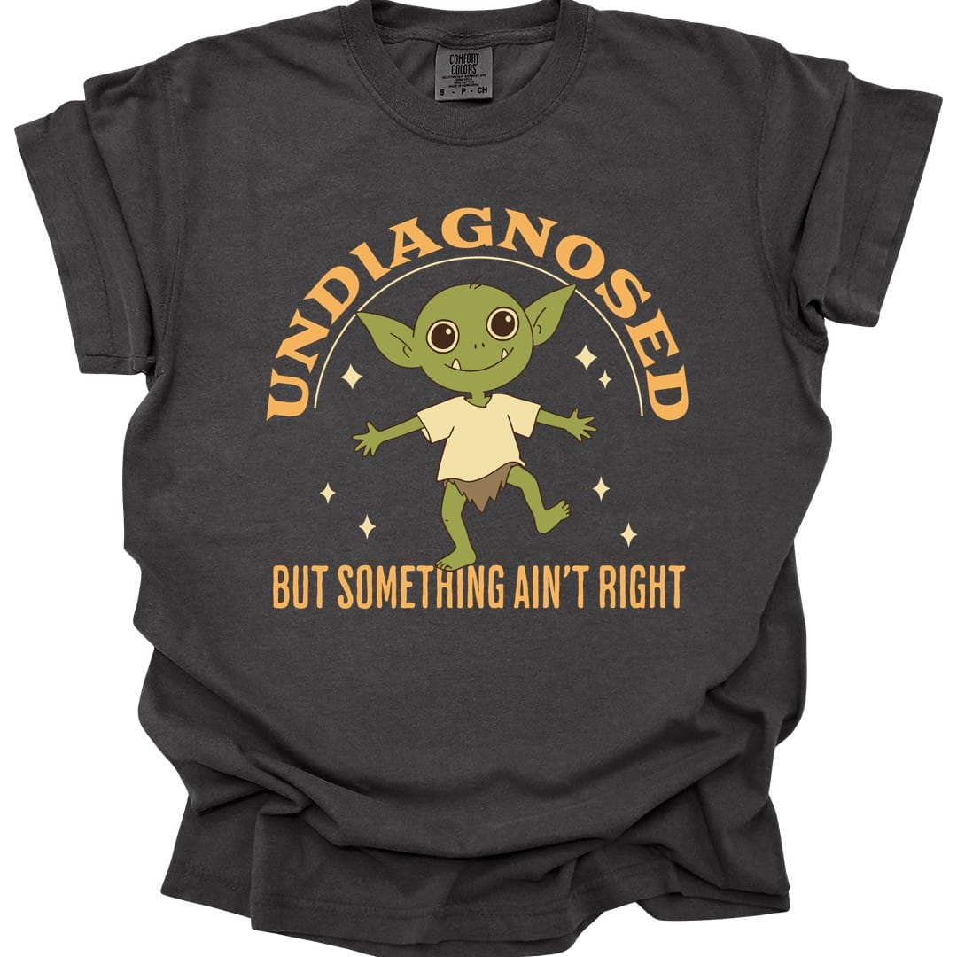 The same Undiagnosed But Something Ain't Right goblin design, on a pepper t-shirt.