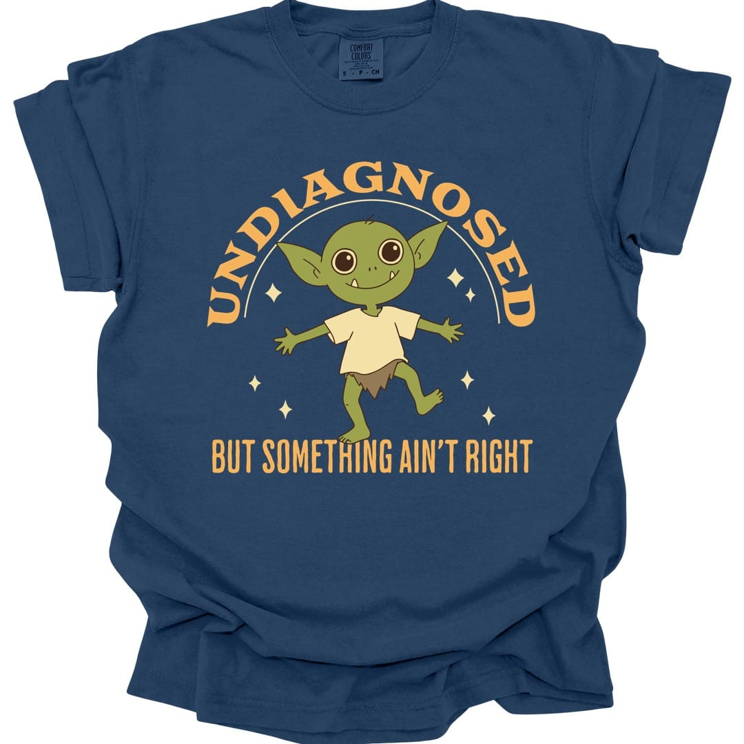 The same Undiagnosed But Something Ain't Right goblin design, on a true navy t-shirt.