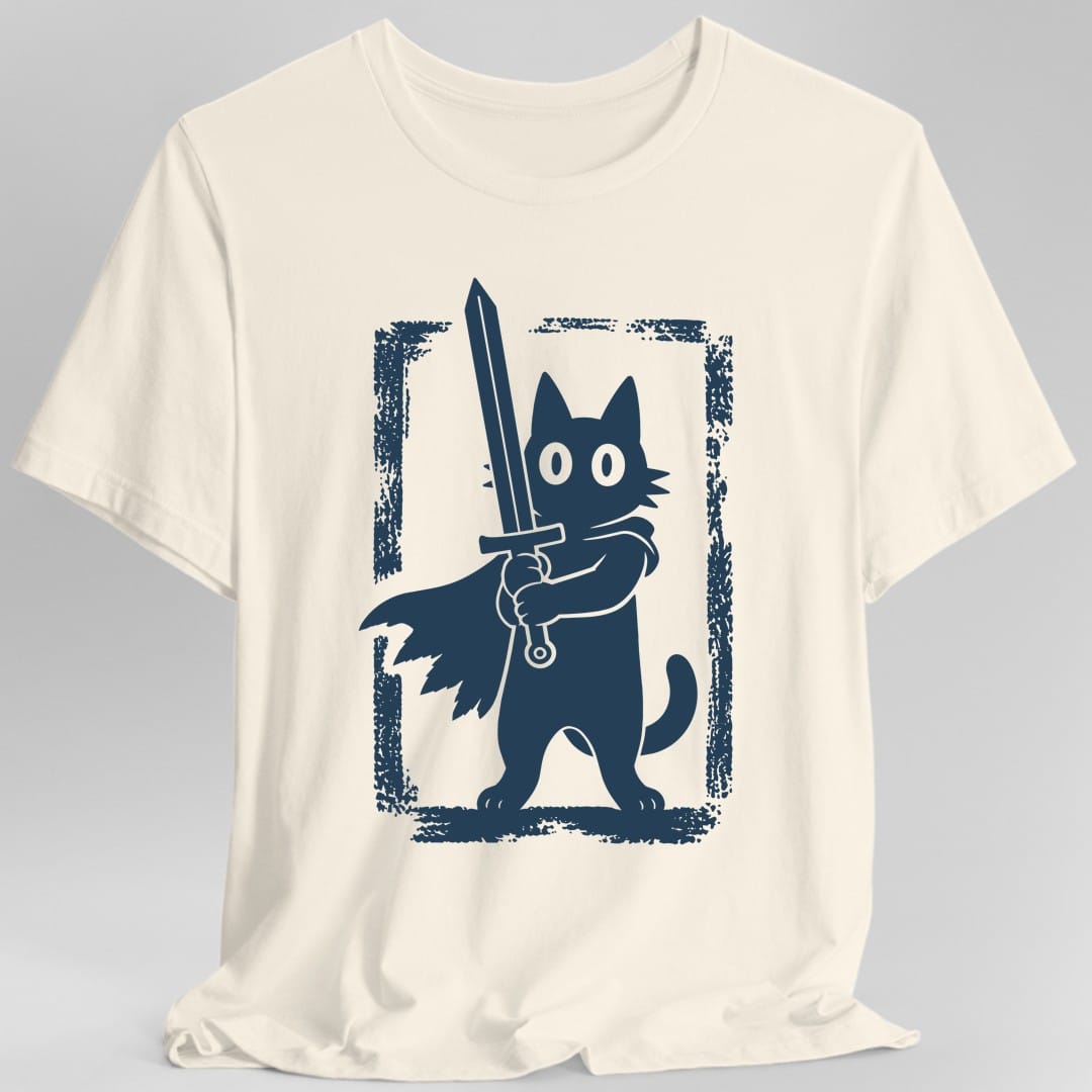 Natural t-shirt. No words. A black cat stands upright on its hind legs in a ragged cape, gripping a long sword point up in both front paws, wide pale eyes staring straight ahead and its tail curled behind. A rough hand printed border frames the whole scene. Drawn as a single color block print.